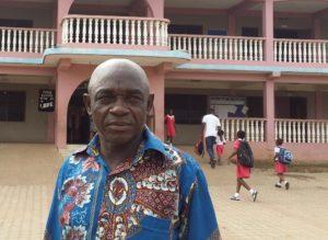 Ghanalaisen koulun työntekijä Paul Antwi-Boasiakoh koulun edustalla.