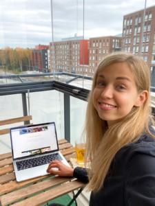 ESC volunteer Roos Freije in front of a table and a laptop at a balcony.