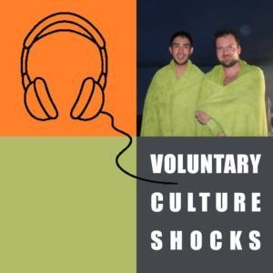 Kaksi henkilöä seisoo vierekkäin ja hymyilee kameralle pyyhkeisiin kietoutuneena, graafinen kuva kuulokkeista sekä teksti "Voluntary Culture Shocks".