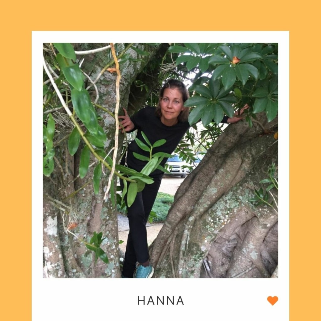 Hymyilevä henkilö puussa, alla teksti "Hanna" ja oranssi sydän.
