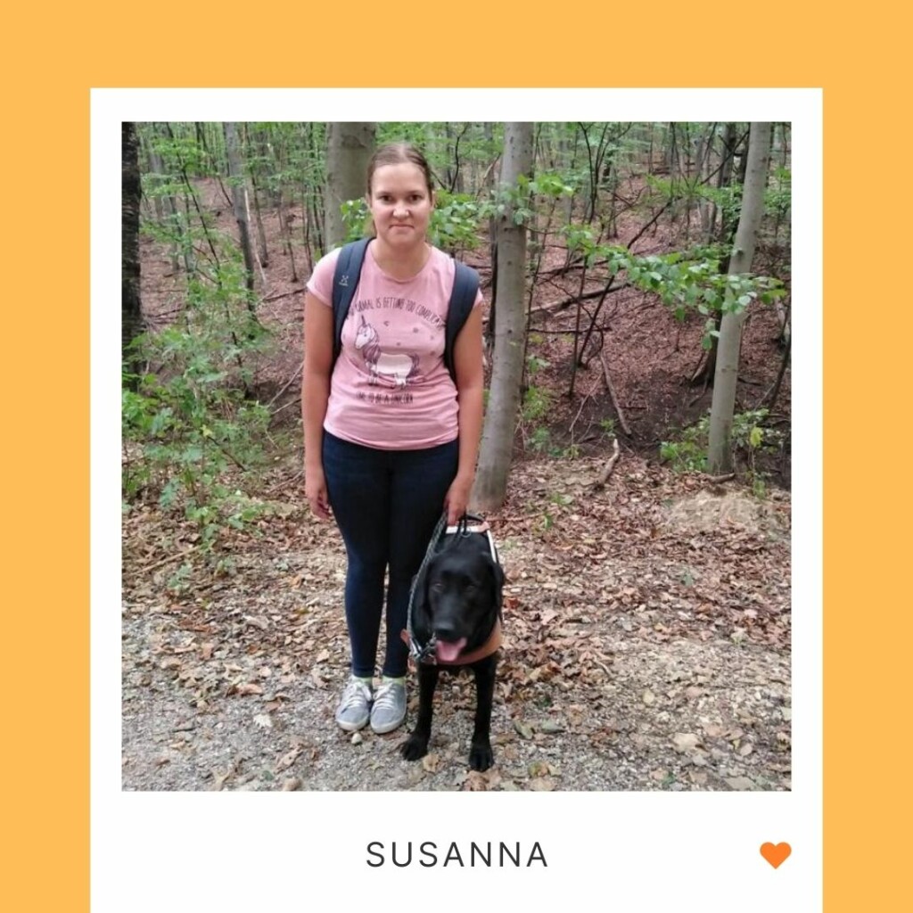 Hymyilevä henkilö seisoo koiran vieressä, taustalla puita, alla teksti "Susanna" ja oranssi sydän.