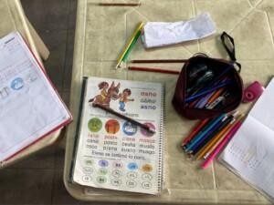 An exercise book and pens on a table.