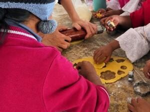 Hands of children and an adult baking.