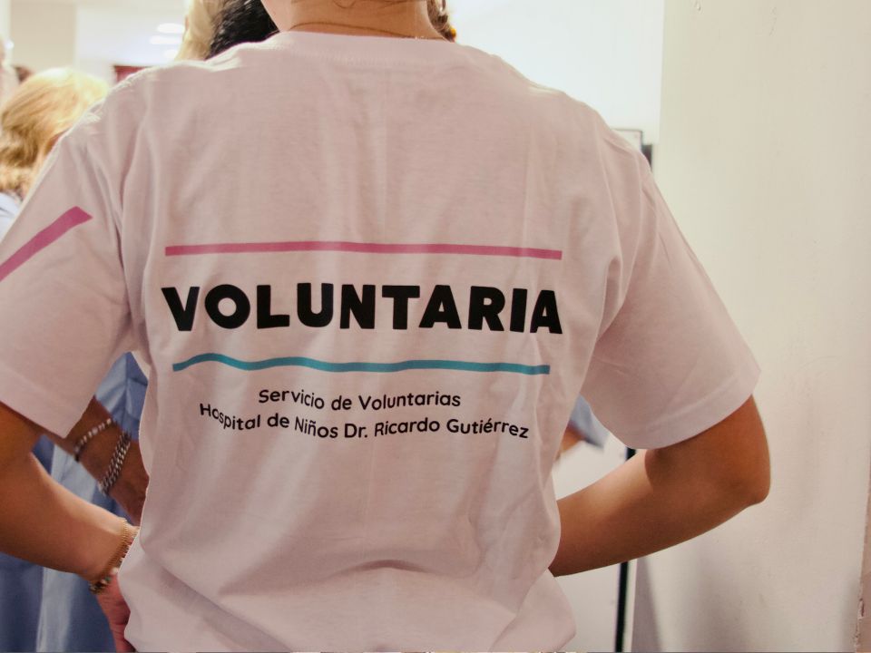 Lähikuva henkilön t-paidan takaosasta, paidassa lukee "Voluntararia – Servicio de Voluntarias, Hospital de Niños Dr. Ricardo Gutiérrez".
